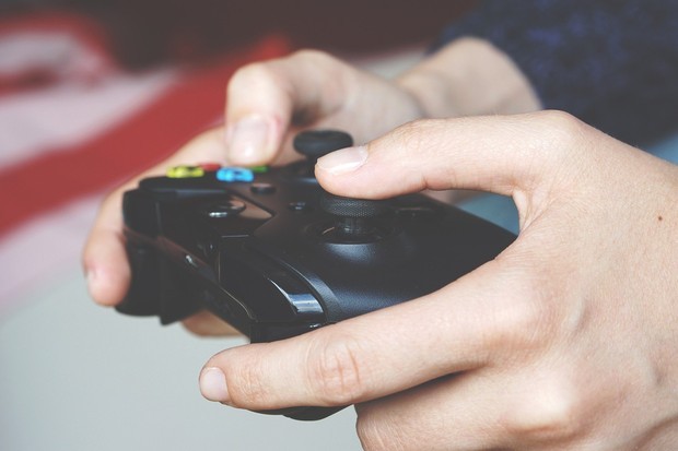 Das Bild zeigt eine Hand mit einem Playstation-Controller. Jemand spielt Playstation. Das Bild zeigt eine Hand mit einem Playstation-Controller. Jemand spielt Playstation.